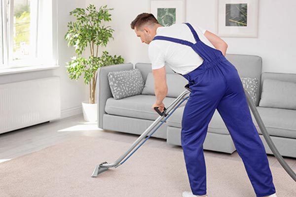 Man cleaning a carpet with a vacuum