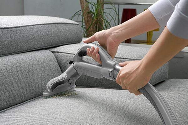 Person vacuuming a couch